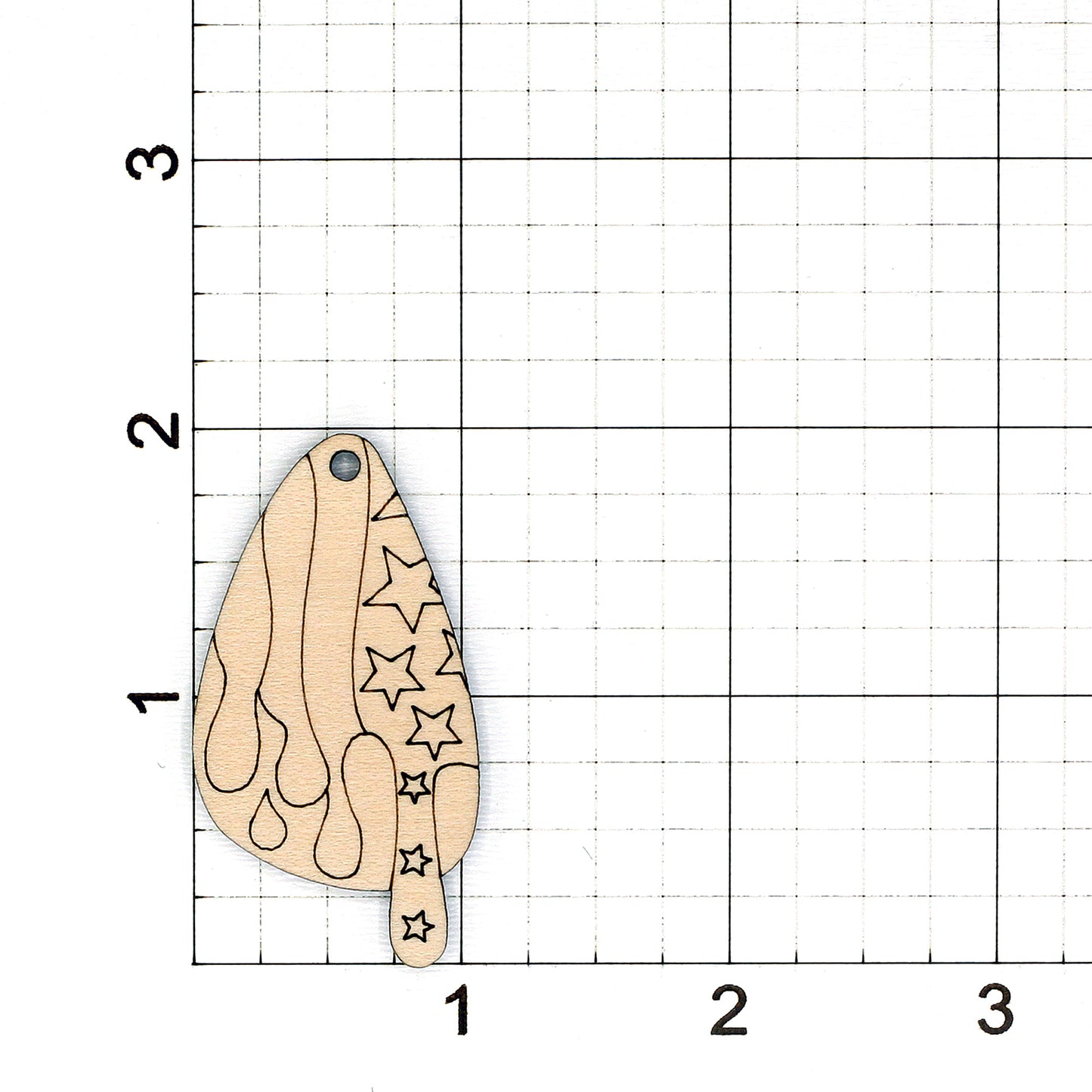 Wooden earring blank with star patterns on a grid background