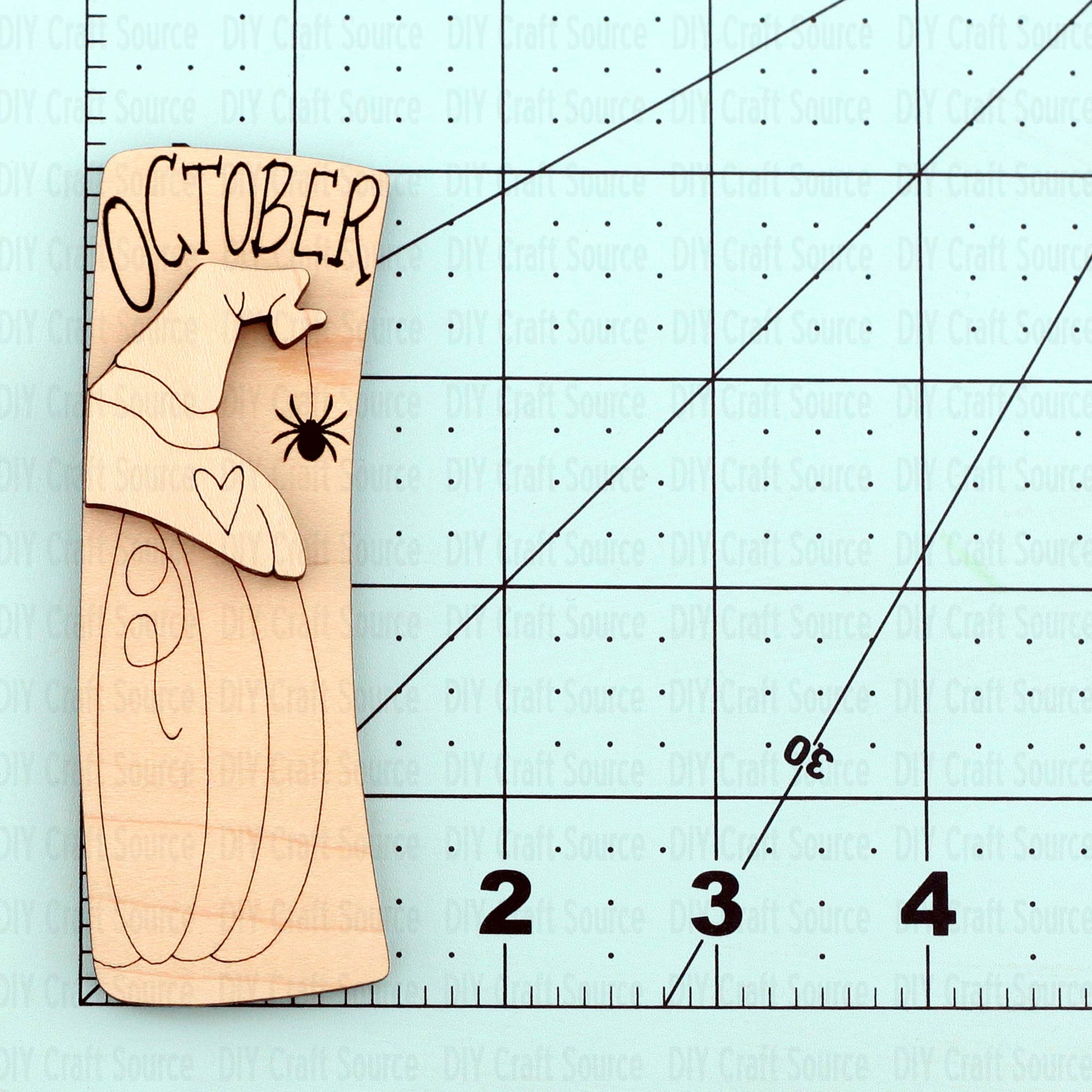 Wooden cutout with 'October' text on a laser cut wood blank for a hair clip