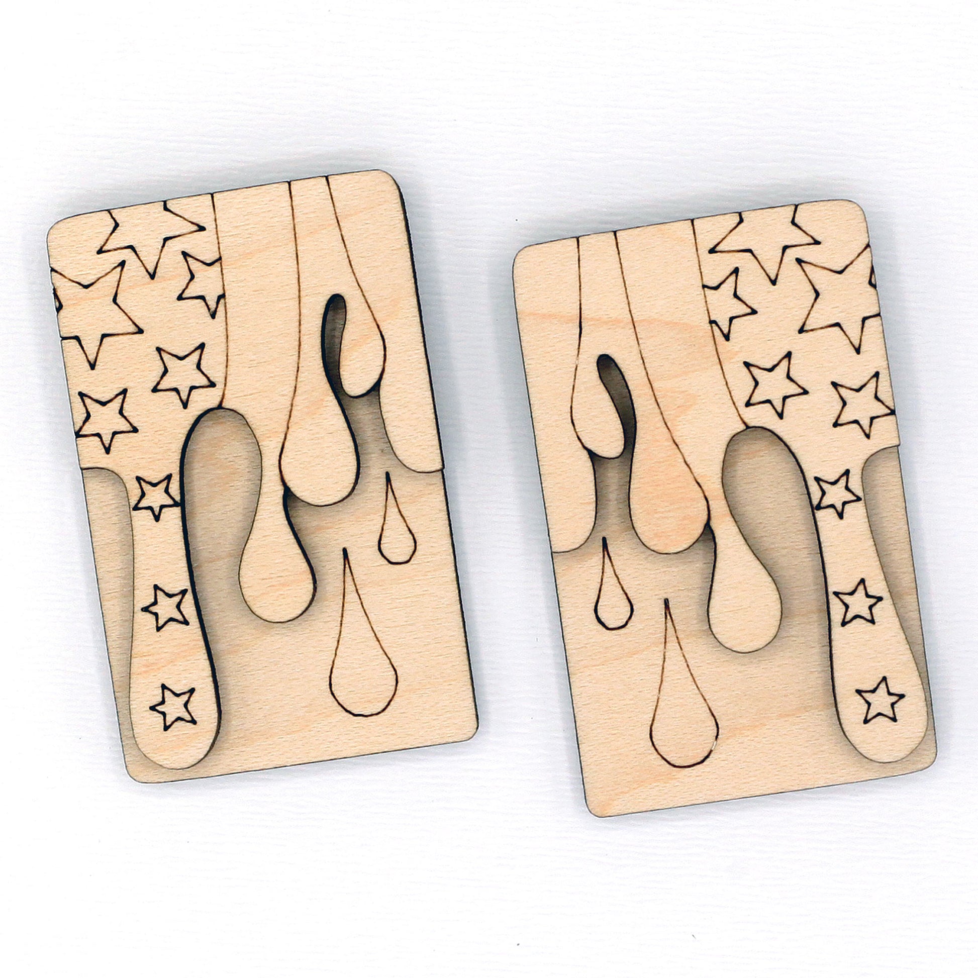 Two wooden hair clip blanks with star and droplet patterns on a white background