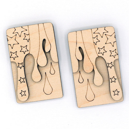 Two wooden hair clip blanks with star and droplet patterns on a white background