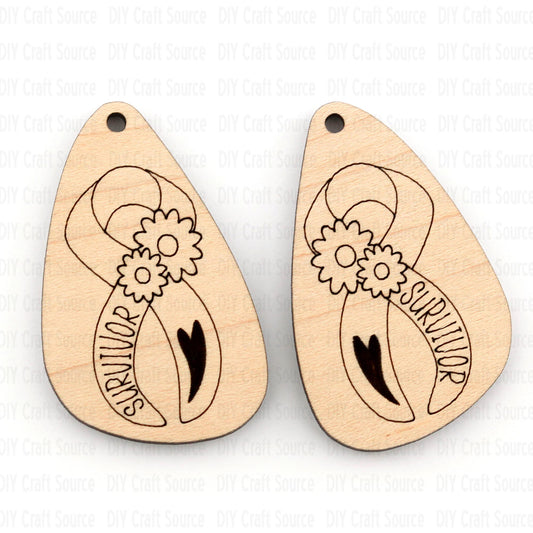 Two wooden teardrop-shaped earring blanks with floral and ribbon designs and 'survivor' text on a light background.