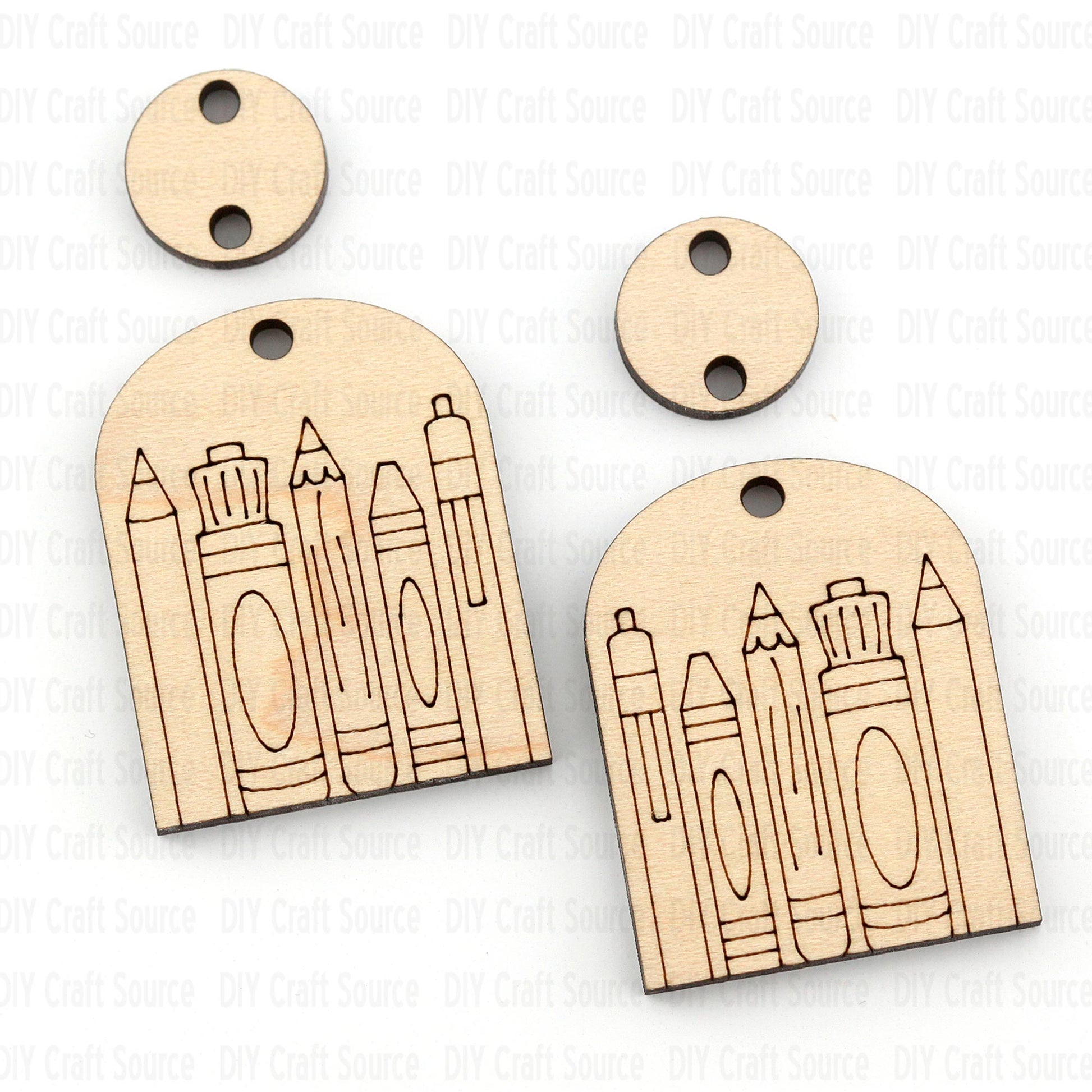Wooden earrings with pencil and crayon designs on a white background that are ready to paint